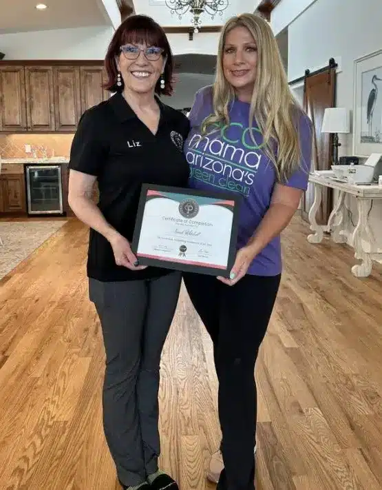 Liz Trotter and a client holding a "Certificate of Completion" in a residential setting, showcasing coaching success in the cleaning industry.