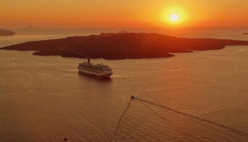 Cruise ship sailing towards sunset over tranquil waters, symbolizing the journey of empowerment and growth for business professionals on the DISC Workshop Cruise.